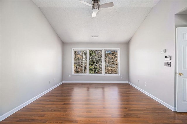 empty room featuring ceiling fan, a textured ceiling, and dark hardwood / wood-style flooring