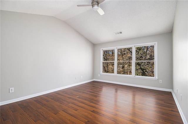 empty room with ceiling fan, dark hardwood / wood-style floors, and vaulted ceiling