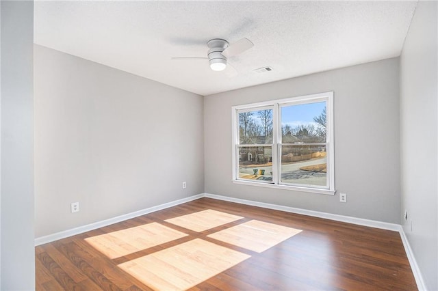 empty room featuring a textured ceiling, wood-type flooring, and ceiling fan