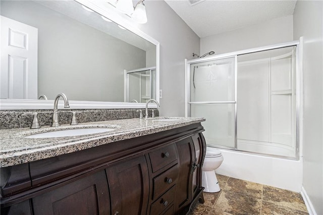 full bathroom with enclosed tub / shower combo, vanity, and toilet