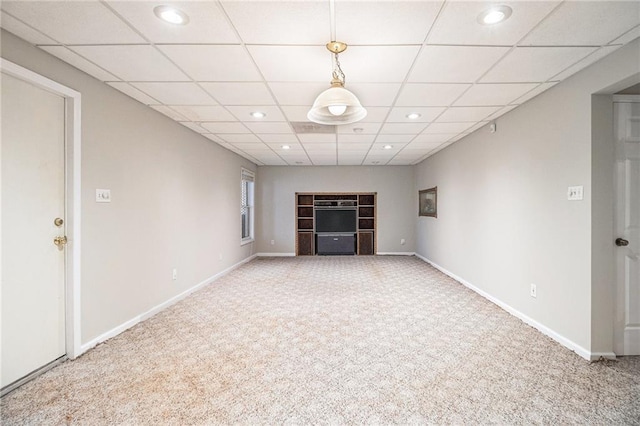 unfurnished living room featuring a paneled ceiling and carpet flooring