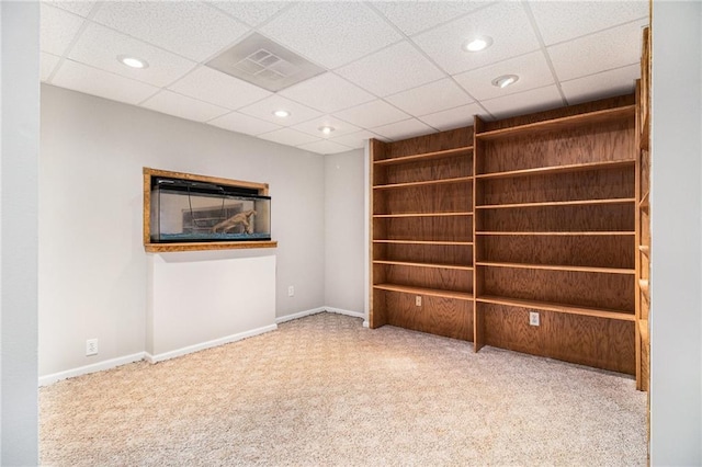 carpeted spare room with a paneled ceiling