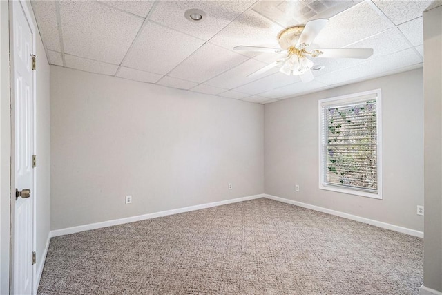 carpeted spare room featuring a paneled ceiling and ceiling fan