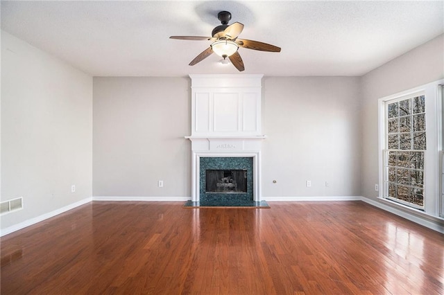 unfurnished living room with dark hardwood / wood-style flooring, a fireplace, and ceiling fan