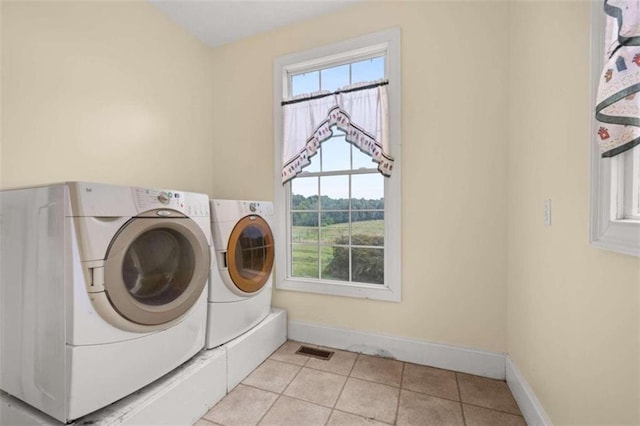 clothes washing area featuring separate washer and dryer and light tile patterned floors