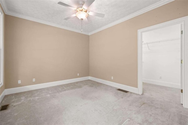 carpeted spare room with a textured ceiling, ceiling fan, and ornamental molding