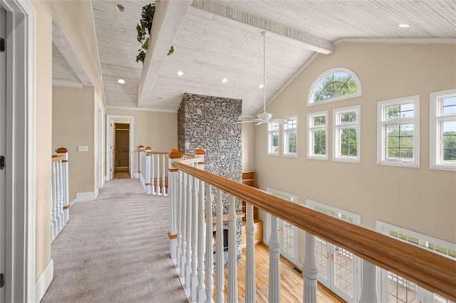 hall featuring beamed ceiling, high vaulted ceiling, wood ceiling, and light colored carpet