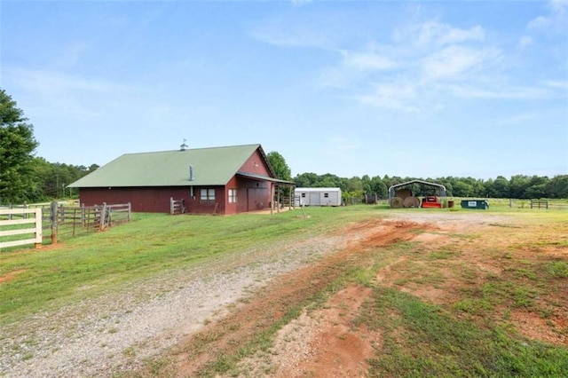 view of yard featuring a rural view and an outdoor structure