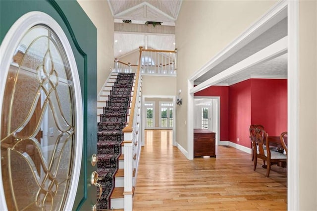 foyer entrance featuring high vaulted ceiling and hardwood / wood-style floors