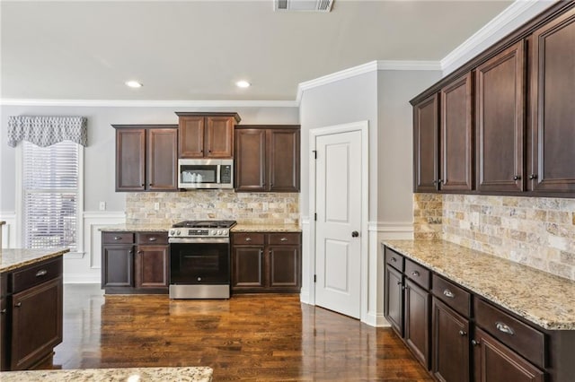 kitchen featuring dark brown cabinets, stainless steel appliances, and light stone counters