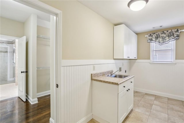 washroom featuring light tile patterned floors, sink, hookup for a washing machine, cabinets, and hookup for an electric dryer