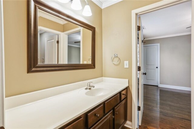 bathroom featuring hardwood / wood-style floors, crown molding, and vanity