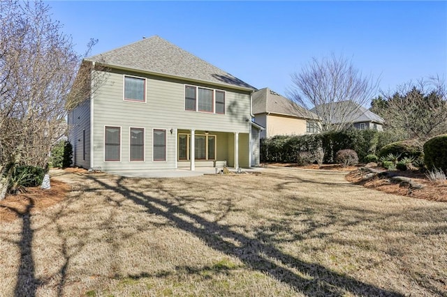 rear view of property with a patio and a lawn