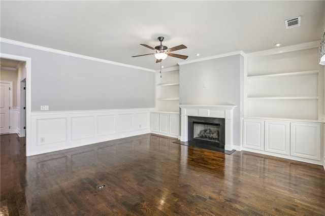 unfurnished living room featuring dark wood-type flooring, ceiling fan, a premium fireplace, crown molding, and built in features