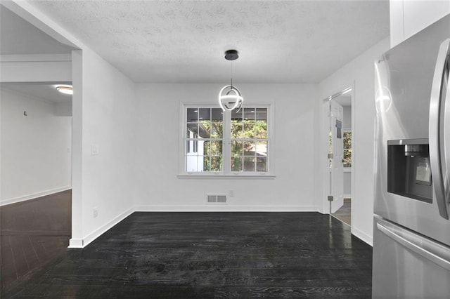 unfurnished dining area featuring dark hardwood / wood-style flooring and a textured ceiling