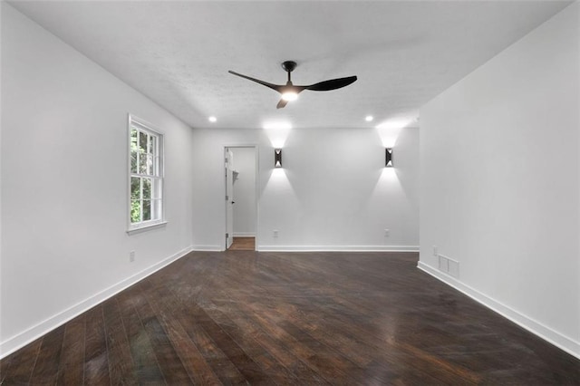 spare room with dark hardwood / wood-style floors and ceiling fan