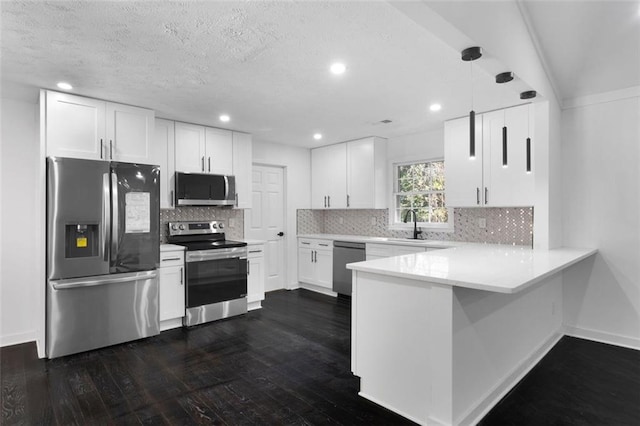 kitchen with dark wood-type flooring, white cabinets, tasteful backsplash, decorative light fixtures, and stainless steel appliances