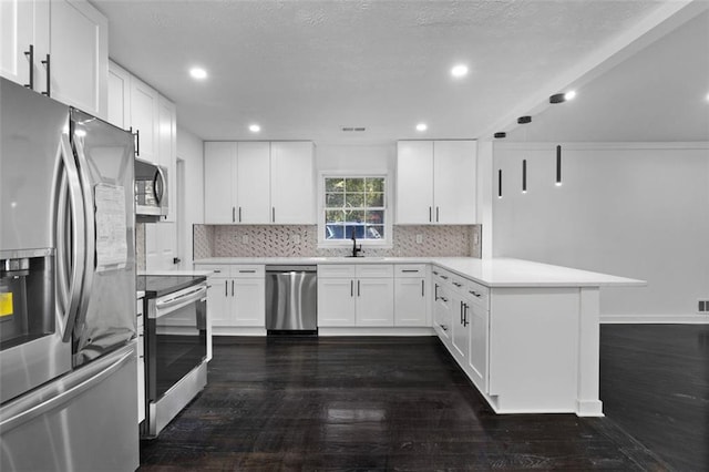 kitchen with dark hardwood / wood-style flooring, backsplash, stainless steel appliances, sink, and white cabinets