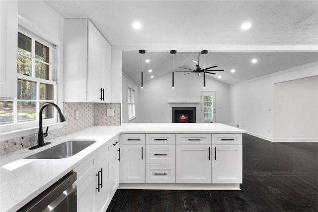 kitchen featuring white cabinets, sink, vaulted ceiling, light stone counters, and kitchen peninsula