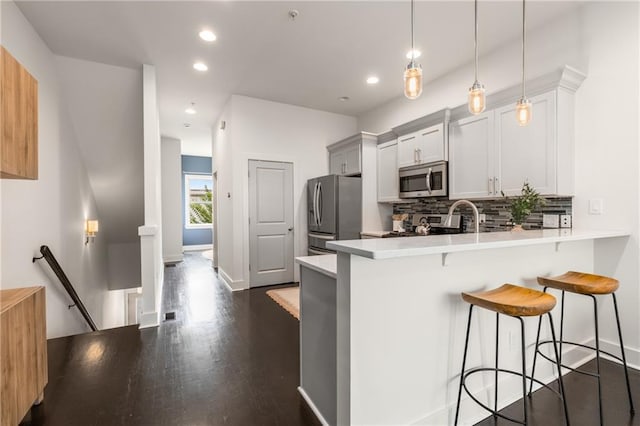 616 Angier Ave NE Unit 4, Atlanta, GA 30308 - kitchen featuring appliances with stainless steel finishes, a breakfast bar area, light countertops, tasteful backsplash, and a peninsula
