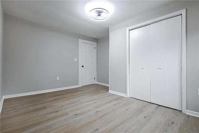 unfurnished bedroom with a closet and light wood-type flooring