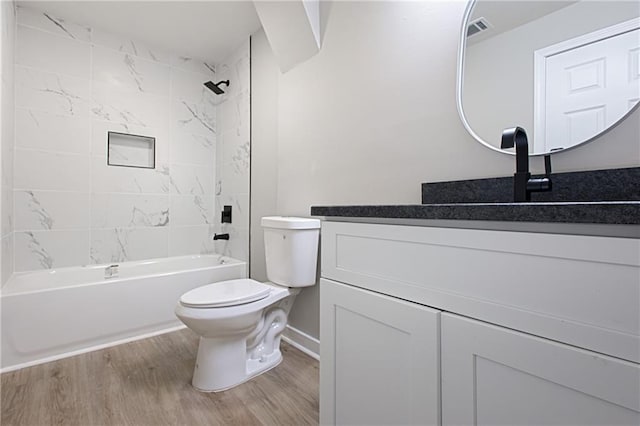 full bathroom with vanity, tiled shower / bath combo, wood-type flooring, and toilet