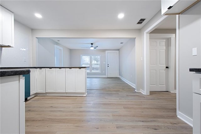 kitchen with tasteful backsplash, ceiling fan, white cabinets, and light wood-type flooring