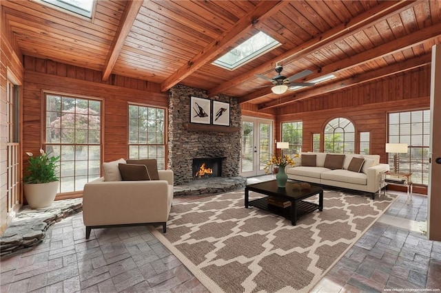 living room with a healthy amount of sunlight, wood walls, and wooden ceiling