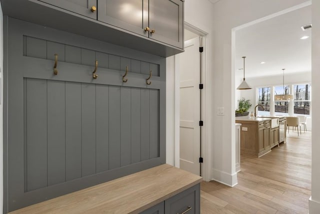 mudroom with light hardwood / wood-style floors