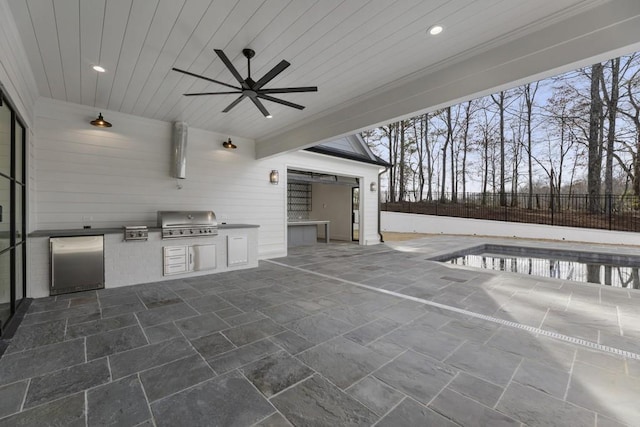 view of patio / terrace with a fenced in pool, exterior kitchen, area for grilling, and ceiling fan