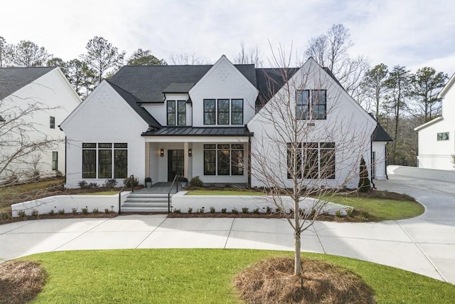 modern farmhouse style home with a garage, a porch, and a front yard