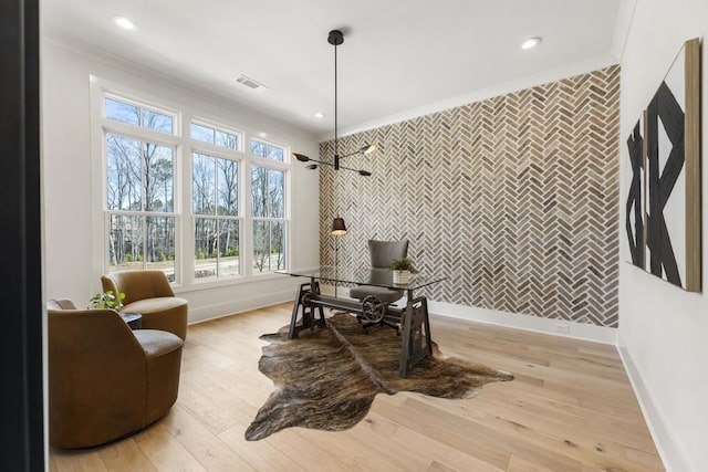 living area with an inviting chandelier, light hardwood / wood-style flooring, and crown molding