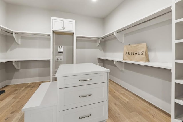 walk in closet with light hardwood / wood-style floors