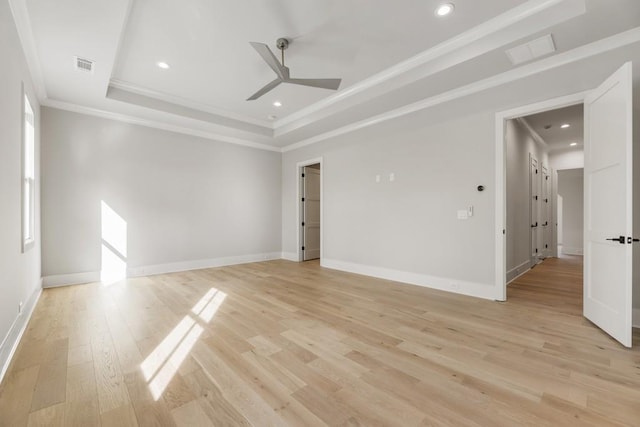 spare room with ornamental molding, a tray ceiling, ceiling fan, and light hardwood / wood-style floors