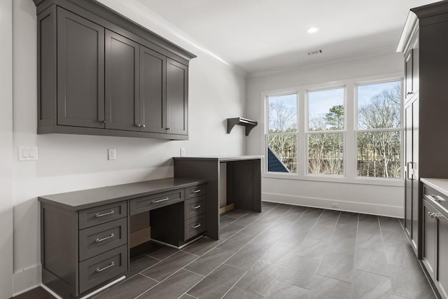 office area featuring built in desk and ornamental molding