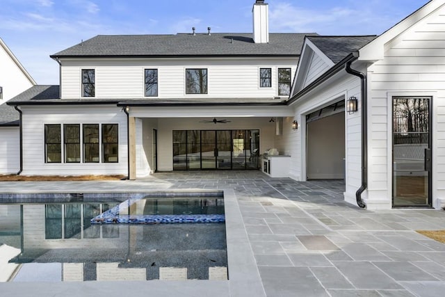 back of property with a patio area, ceiling fan, and a pool with hot tub