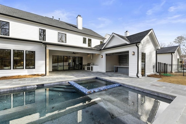 back of property featuring ceiling fan, a swimming pool with hot tub, and a patio area