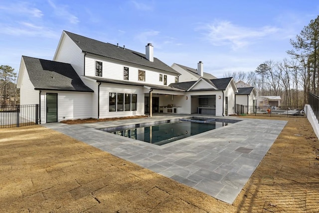 rear view of property featuring a fenced in pool and a patio area