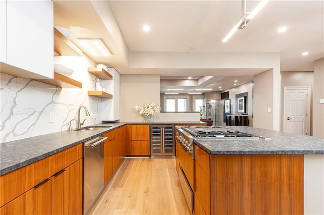 kitchen featuring wine cooler, sink, range, light hardwood / wood-style flooring, and stainless steel dishwasher