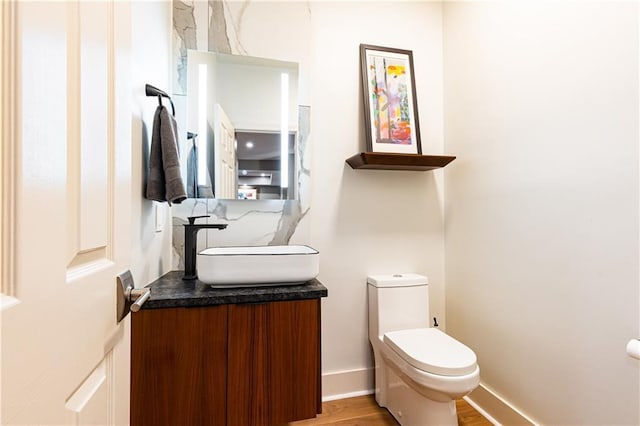 bathroom featuring hardwood / wood-style flooring, vanity, and toilet