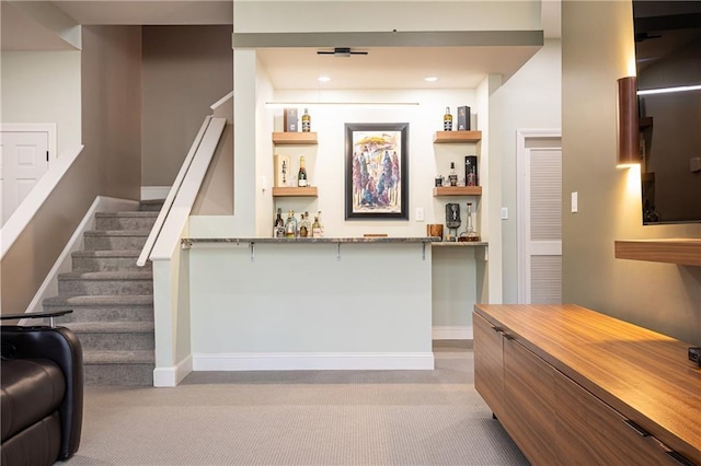 bar with light stone countertops, light colored carpet, and built in features