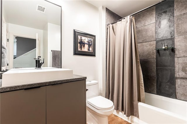 full bathroom featuring hardwood / wood-style flooring, vanity, toilet, and shower / bath combo