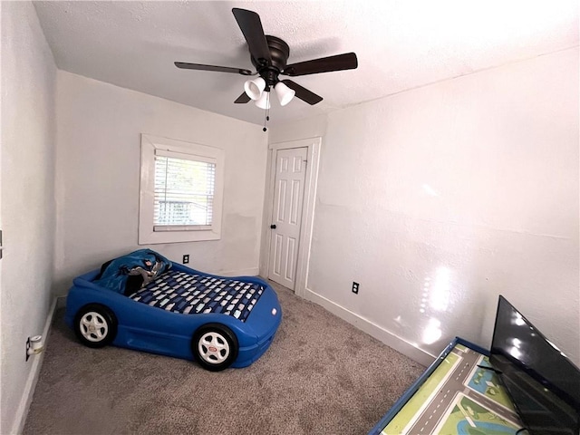 bedroom featuring baseboards, carpet floors, a textured ceiling, and a ceiling fan