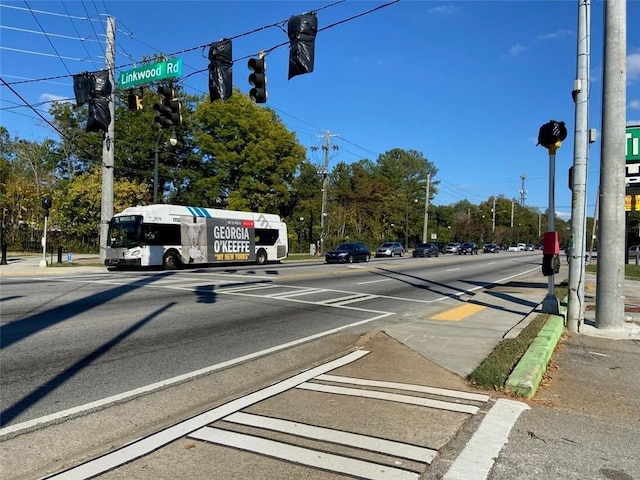 view of road with curbs, traffic lights, and sidewalks