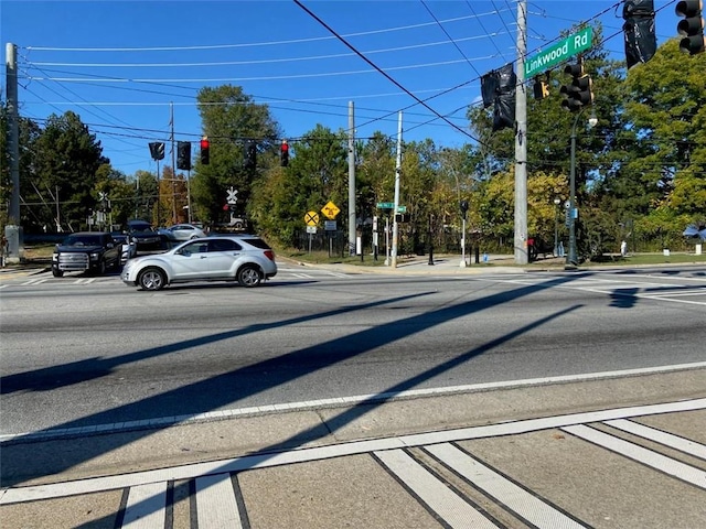 view of road featuring traffic signs, traffic lights, and sidewalks