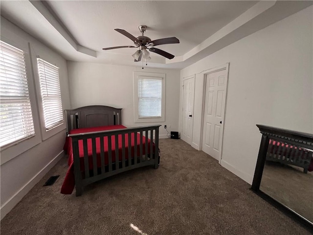 bedroom with carpet flooring, baseboards, and a tray ceiling