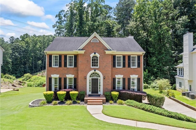 2500 Ashbourne Dr, Lawrenceville, GA 30043 - colonial house featuring a front lawn, brick siding, and a chimney