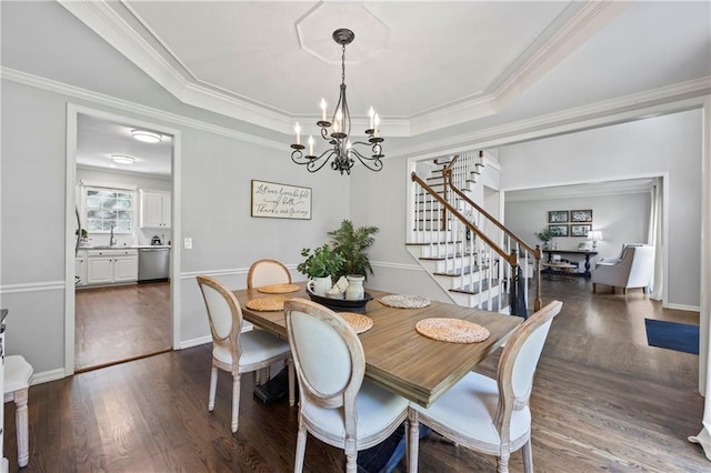 2500 Ashbourne Dr, Lawrenceville, GA 30043 - dining area with a chandelier, stairs, dark wood-style flooring, a raised ceiling, and crown molding