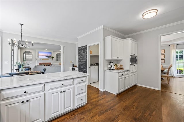 2500 Ashbourne Dr, Lawrenceville, GA 30043 - kitchen featuring stainless steel microwave, washing machine and dryer, a chandelier, white cabinetry, and dark wood-type flooring