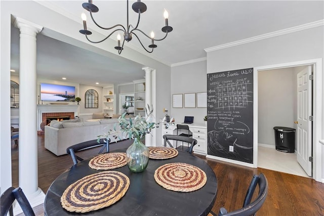 2500 Ashbourne Dr, Lawrenceville, GA 30043 - dining space featuring crown molding, decorative columns, wood finished floors, a chandelier, and a fireplace